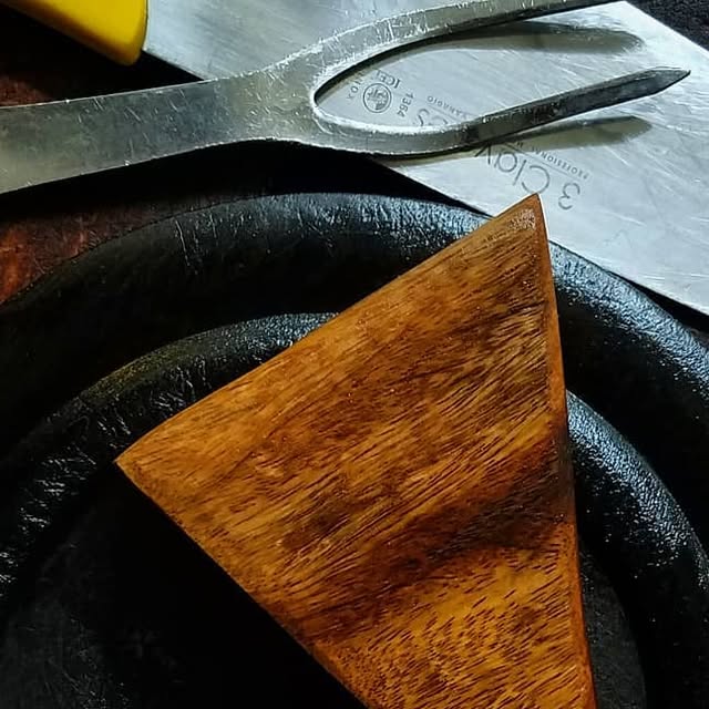 Detalle de un taco triangular de madera utilizado en el servicio de La Mezzetta.
